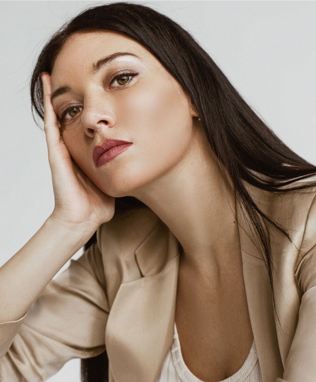 Model with long hair in neutral blazer.