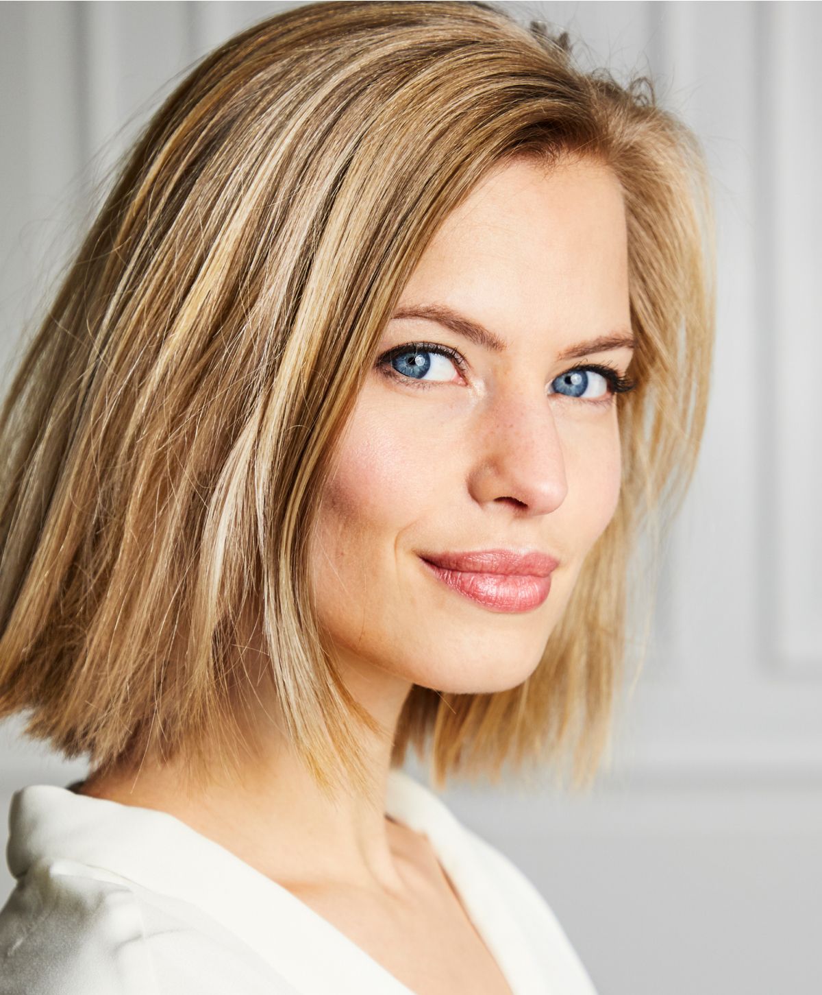 Smiling woman with blonde hair and blue eyes.
