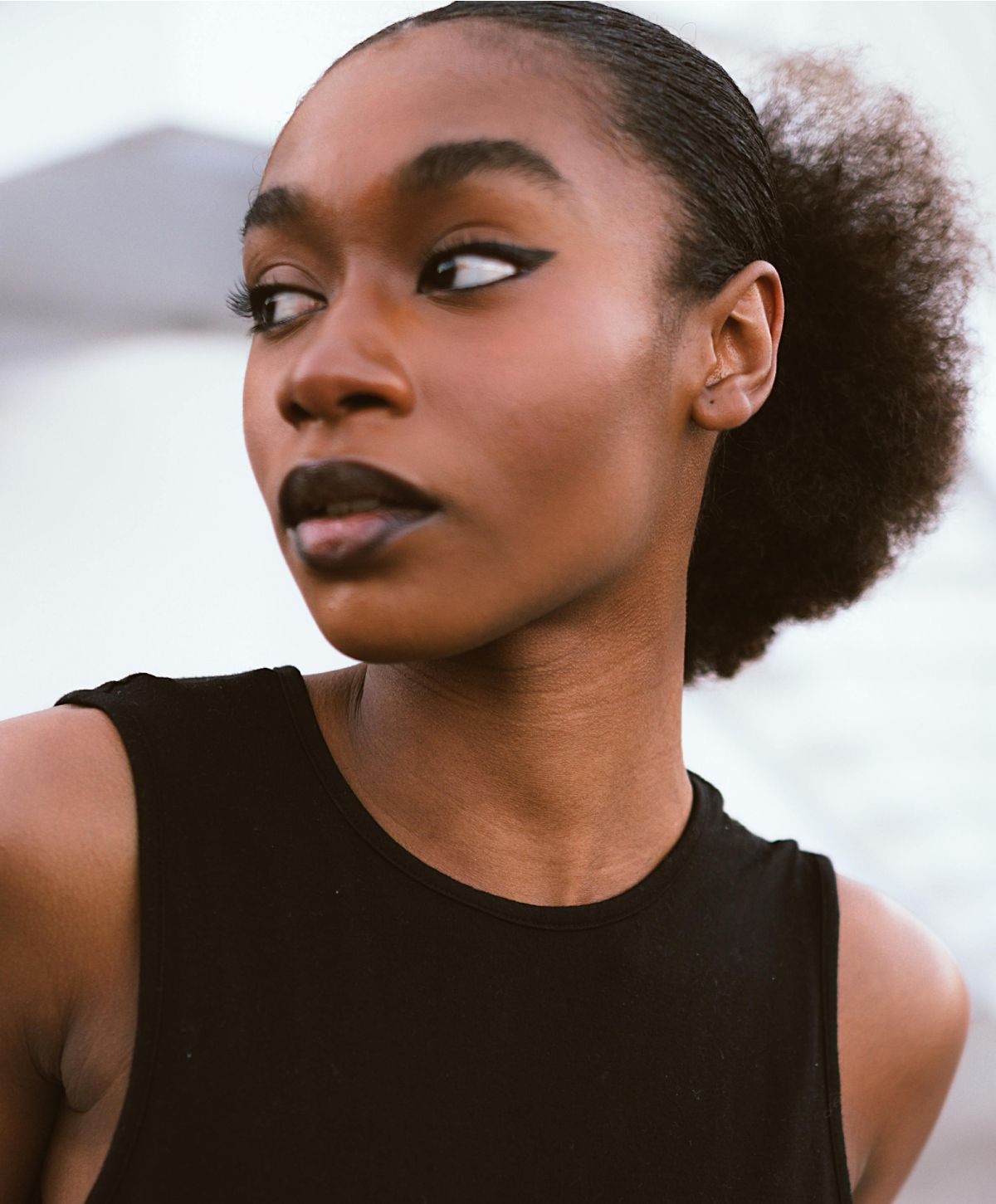 Young woman with striking makeup and hairstyle.