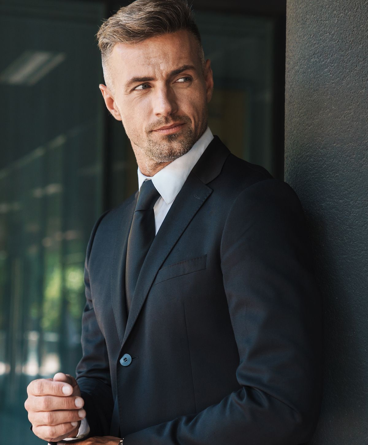 Man in suit looking confidently to the side.