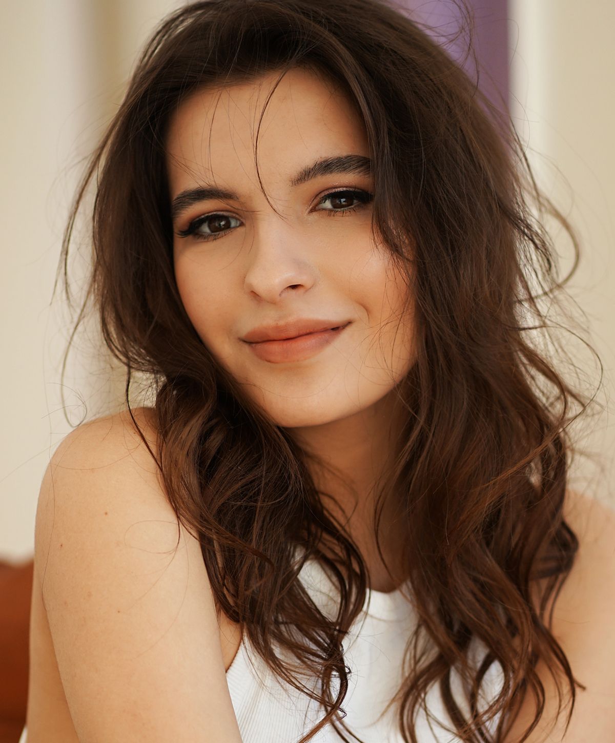 Smiling woman with wavy hair and natural makeup.