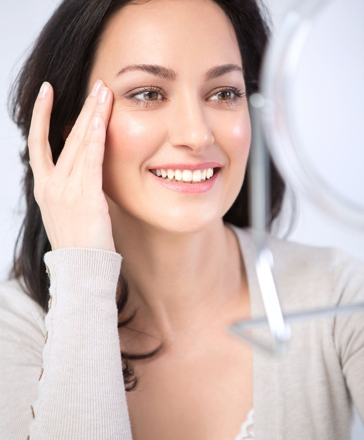 Woman smiling while looking in a mirror.