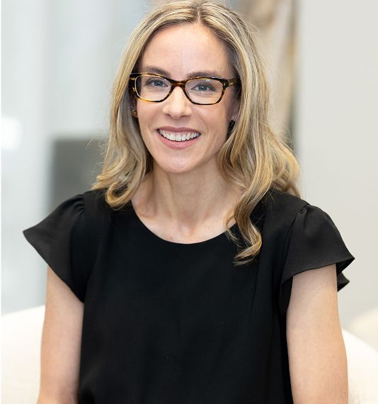 Smiling woman with glasses in black top