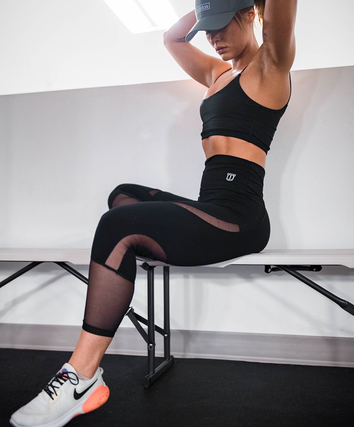 Woman in stylish lingerie poses near a wall.
