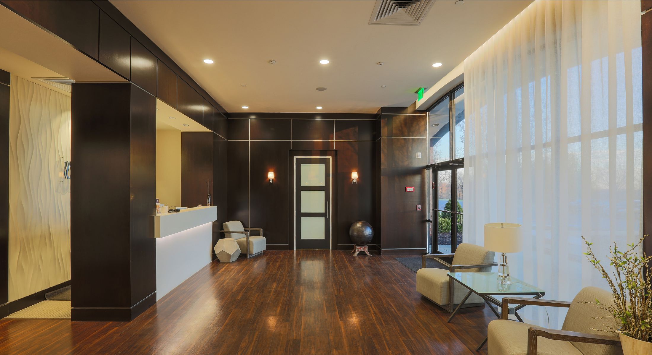 Modern healthcare reception area with desk and decor.