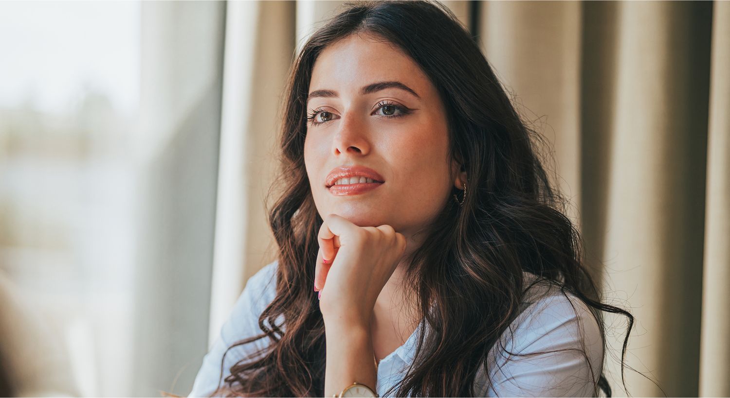 Smiling young woman with long hair outdoors.