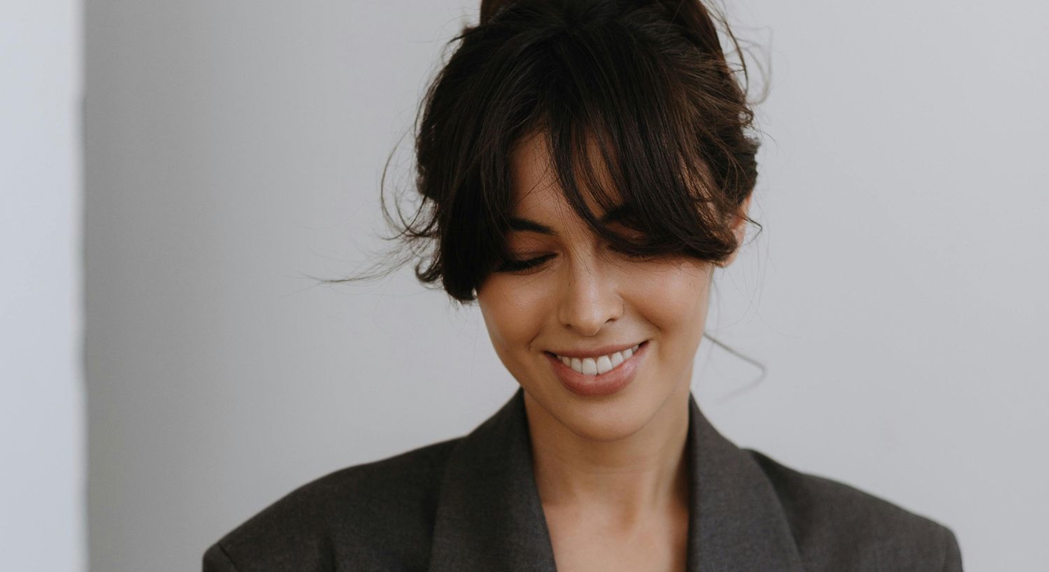 Smiling woman with long hair in blazer.