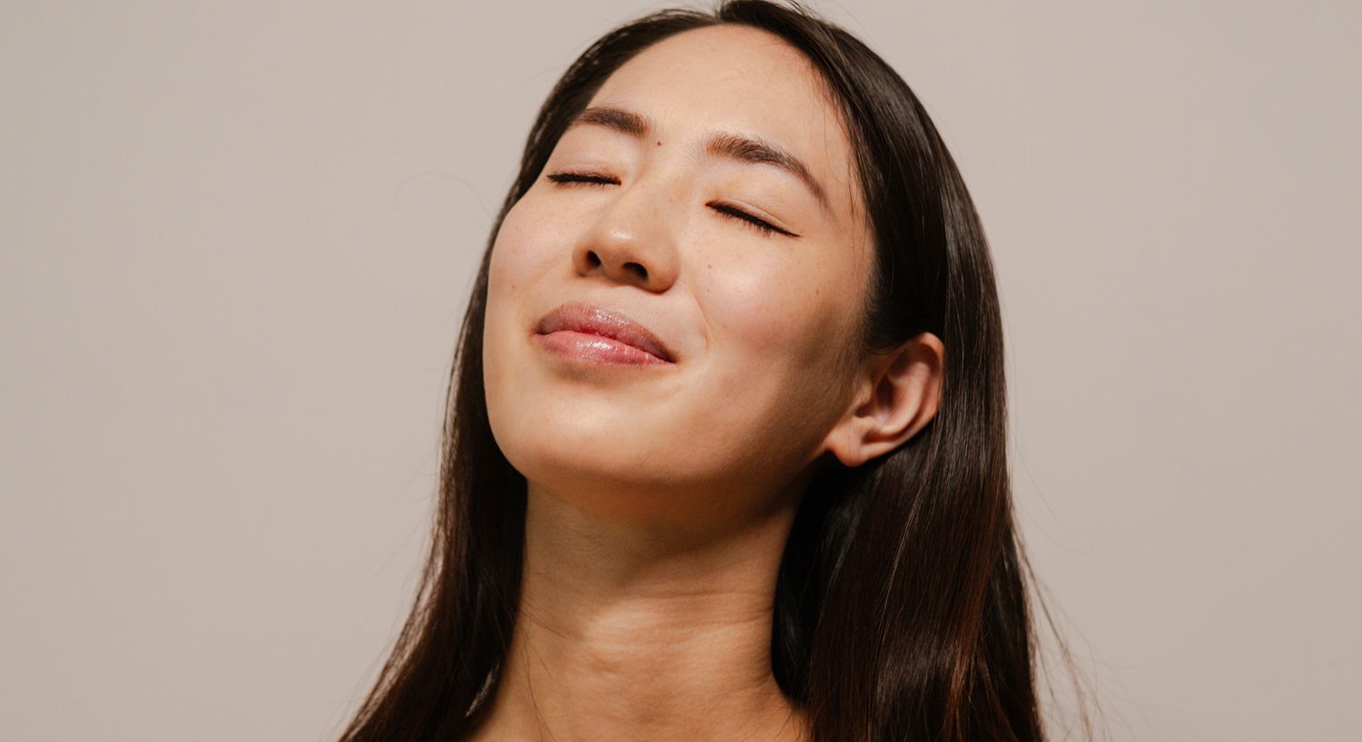 Woman smiling peacefully with eyes closed.