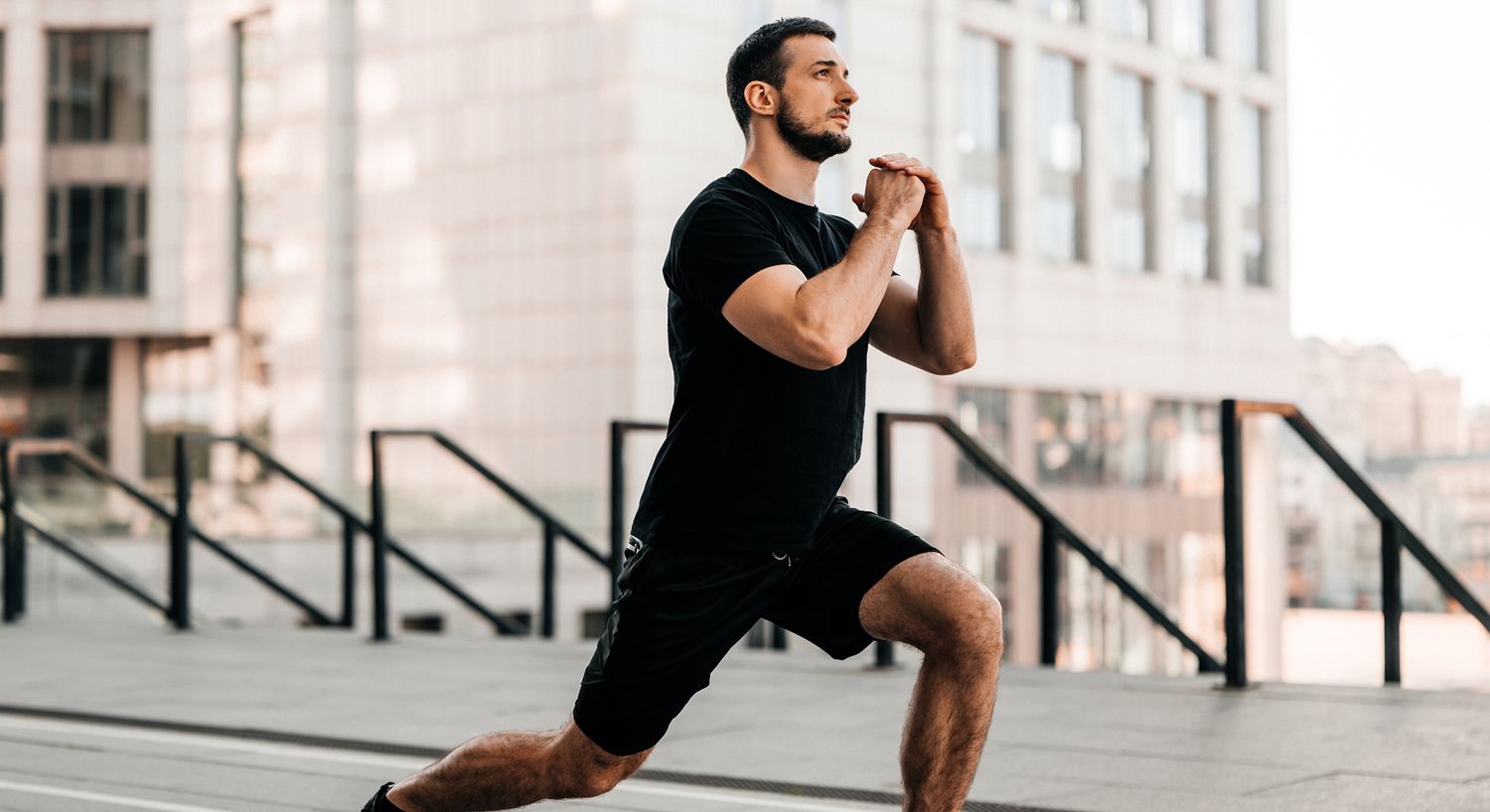 Woman stretching in sporty attire by a wall.